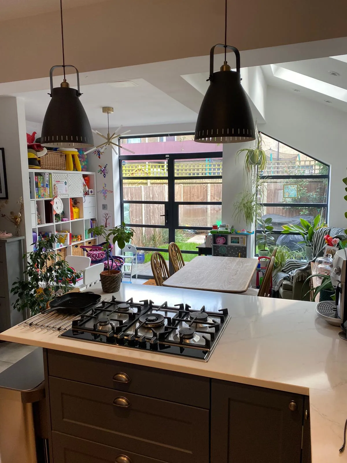 Open-plan kitchen with island, pendant lights and garden views