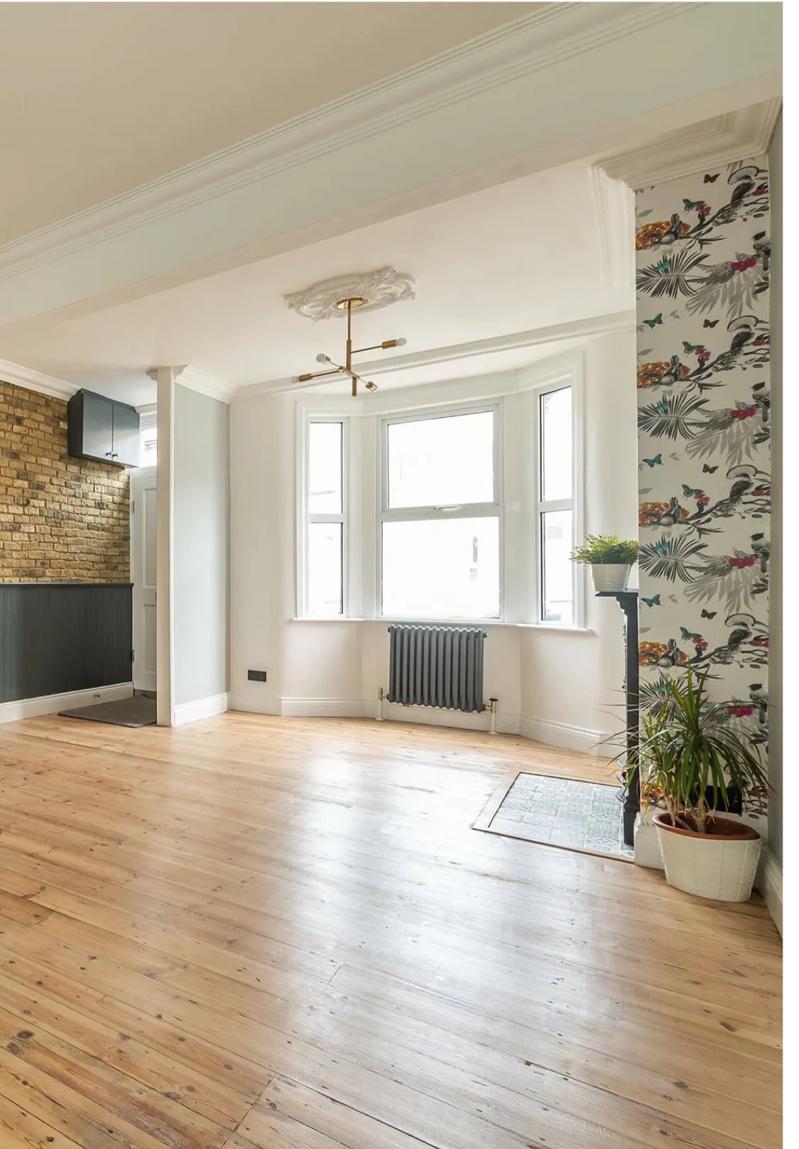 Restored living room with bay window, period ceiling rose and original floorboards