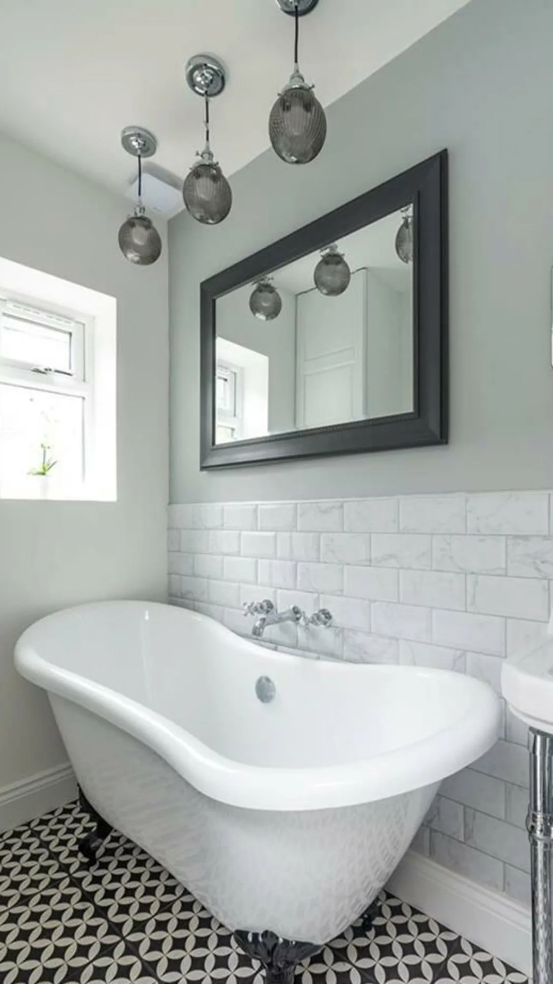 Bathroom with freestanding clawfoot bathtub and marble subway tiles