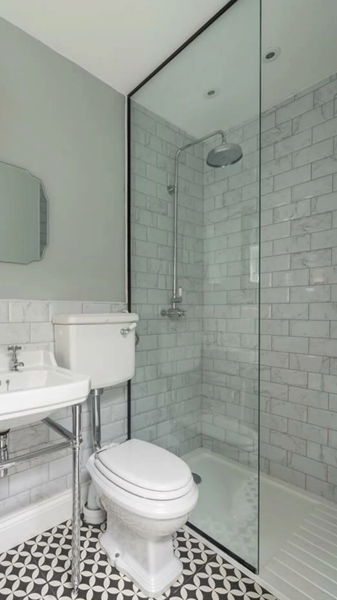 Walk-in shower with marble tiles and geometric floor