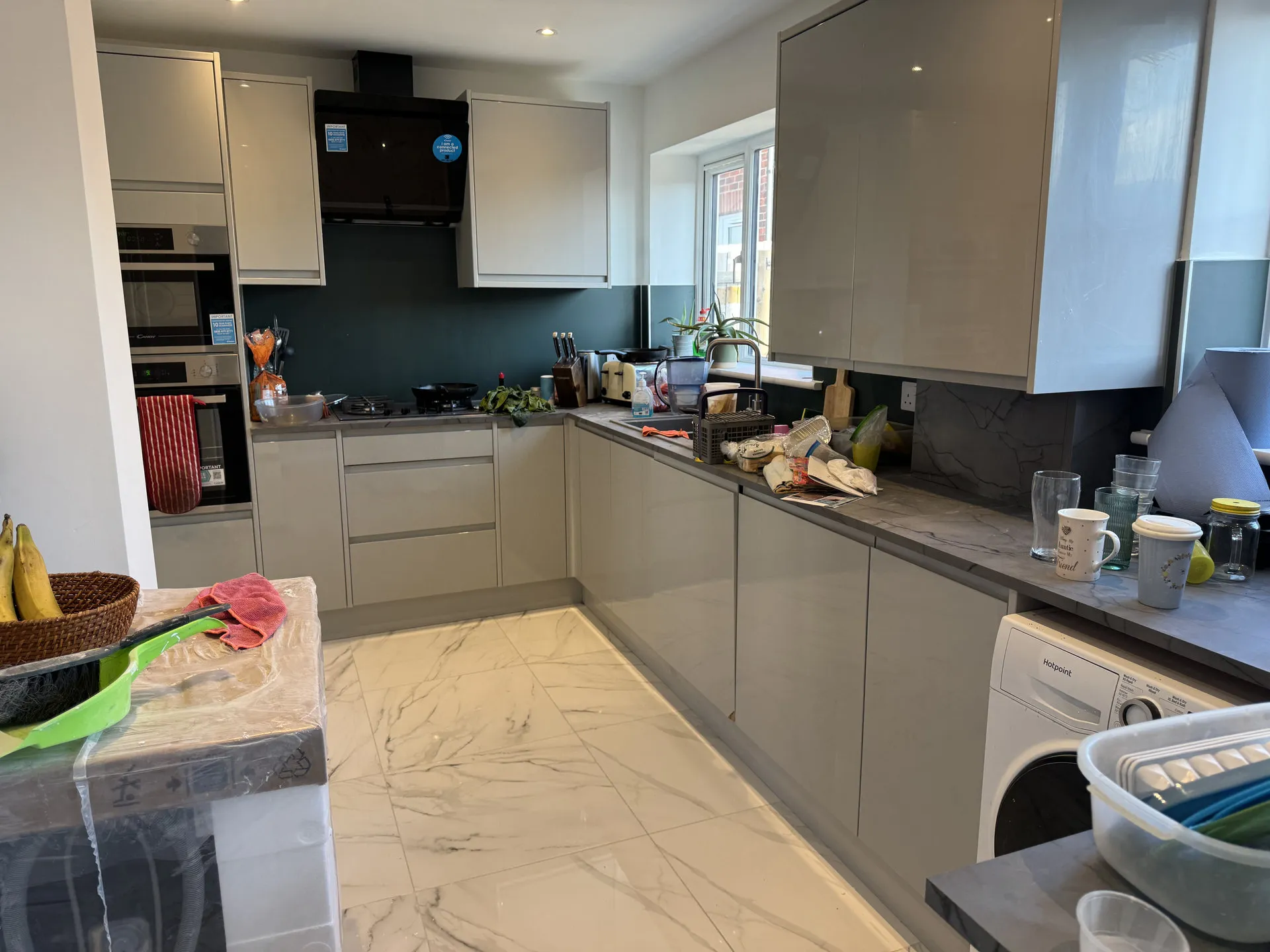 New kitchen with modern grey cabinets and marble flooring
