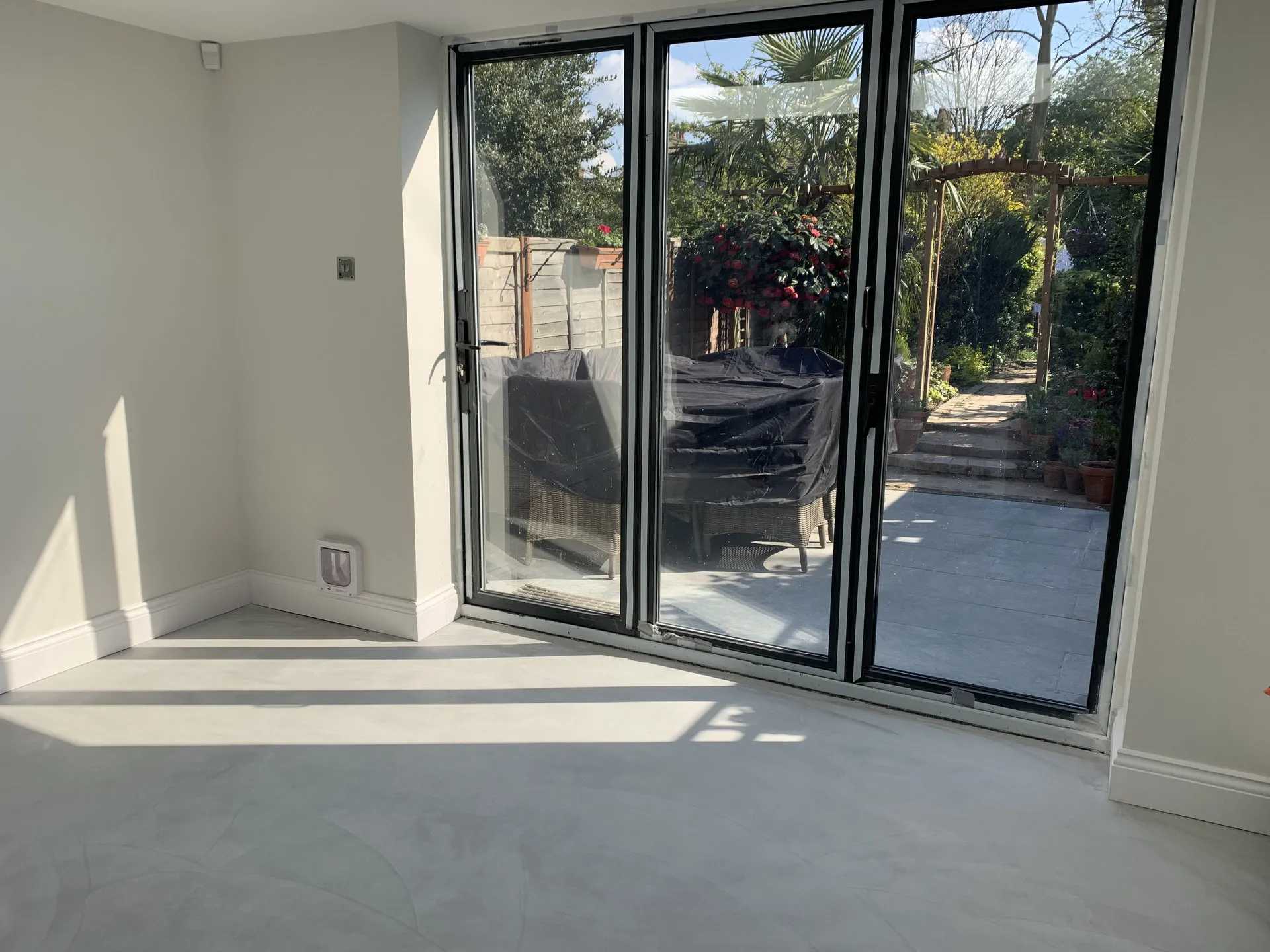 Finished open-plan room with bifold doors opening to the garden